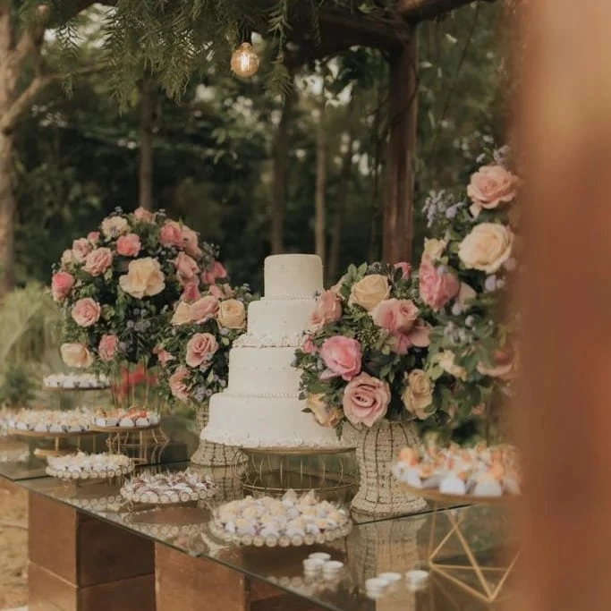 Mesa de bolo de casamento decorada com rosas